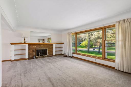 Featuring a neutral palette and large picture window offering peaceful views of the expansive front yard.