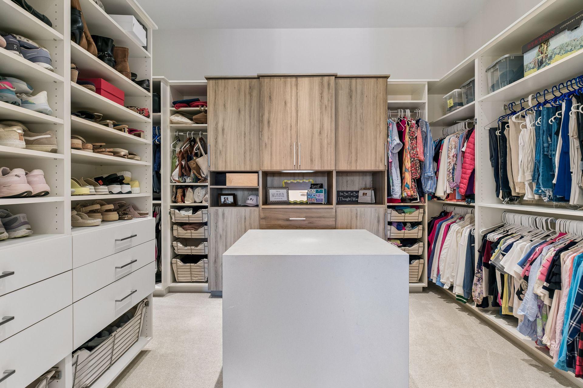 Luxurious primary walk-in closet with built in organizational components and center island