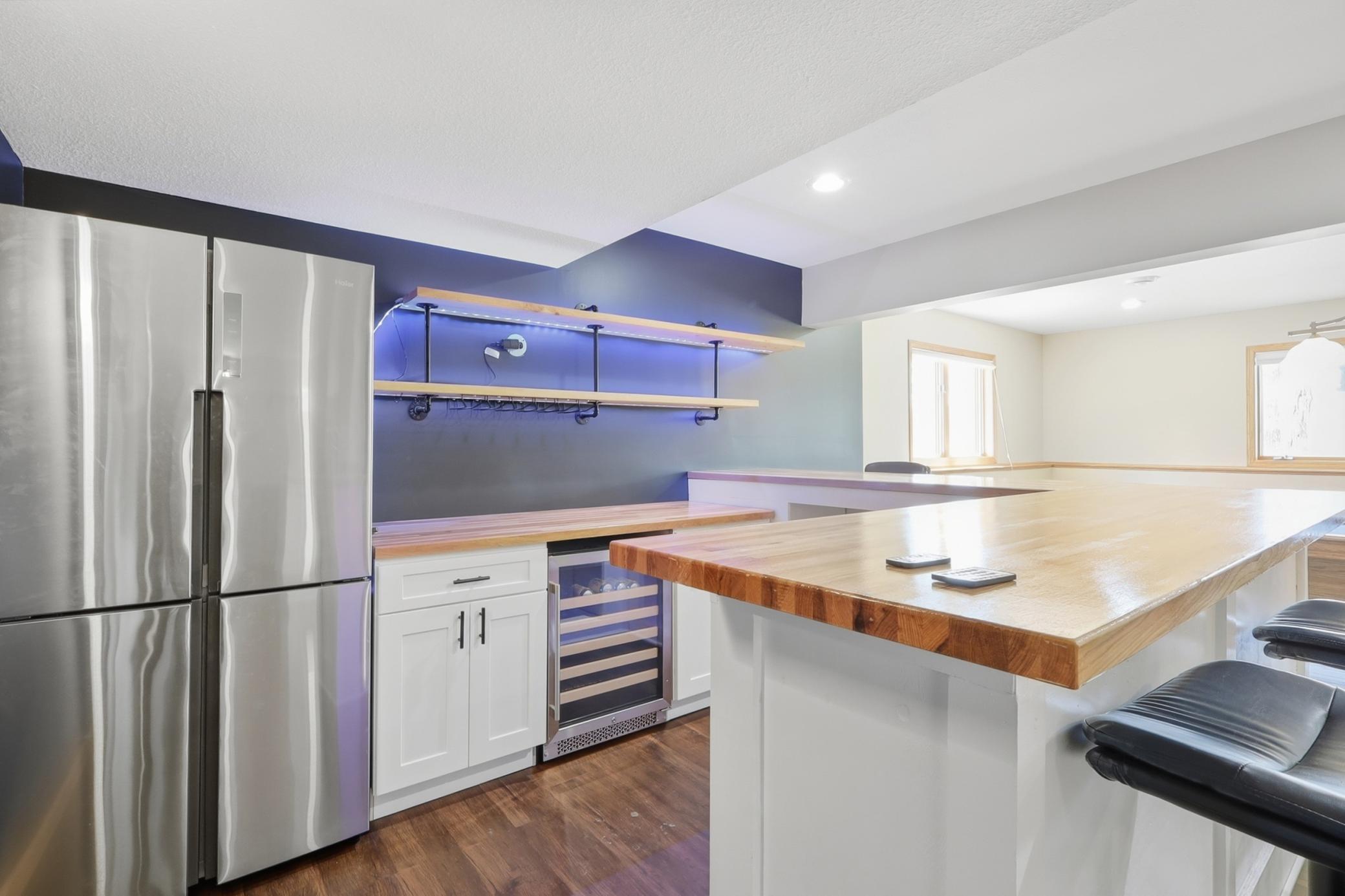 Lower level entertainment area featuring a built in dry bar, perfect for hosting guests or relaxing nights at home.