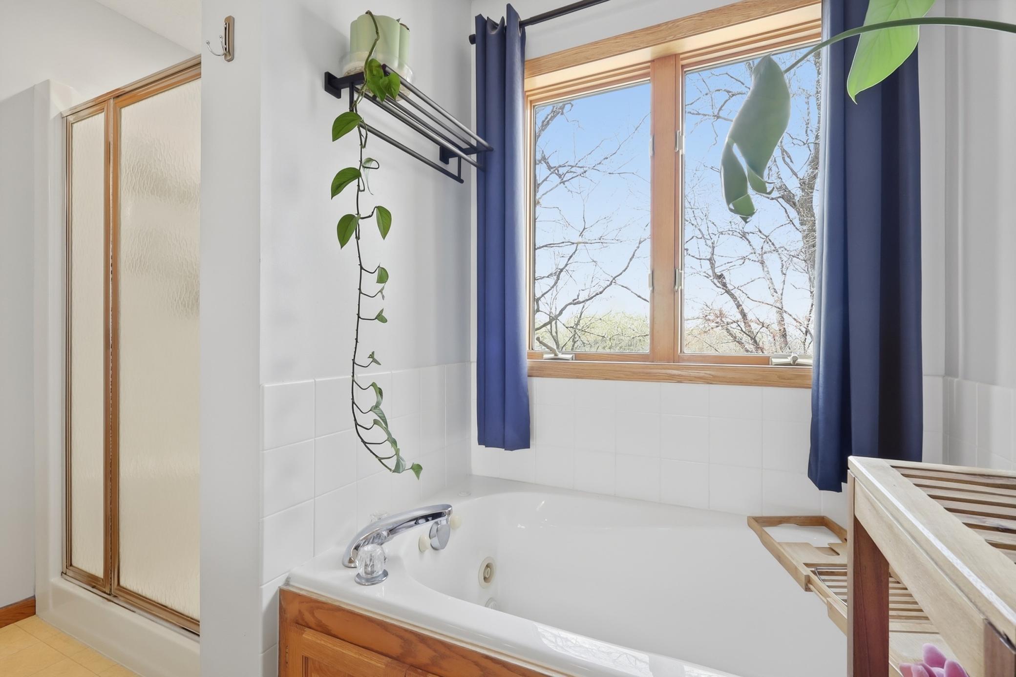 private ensuite featuring a separate tub and shower.