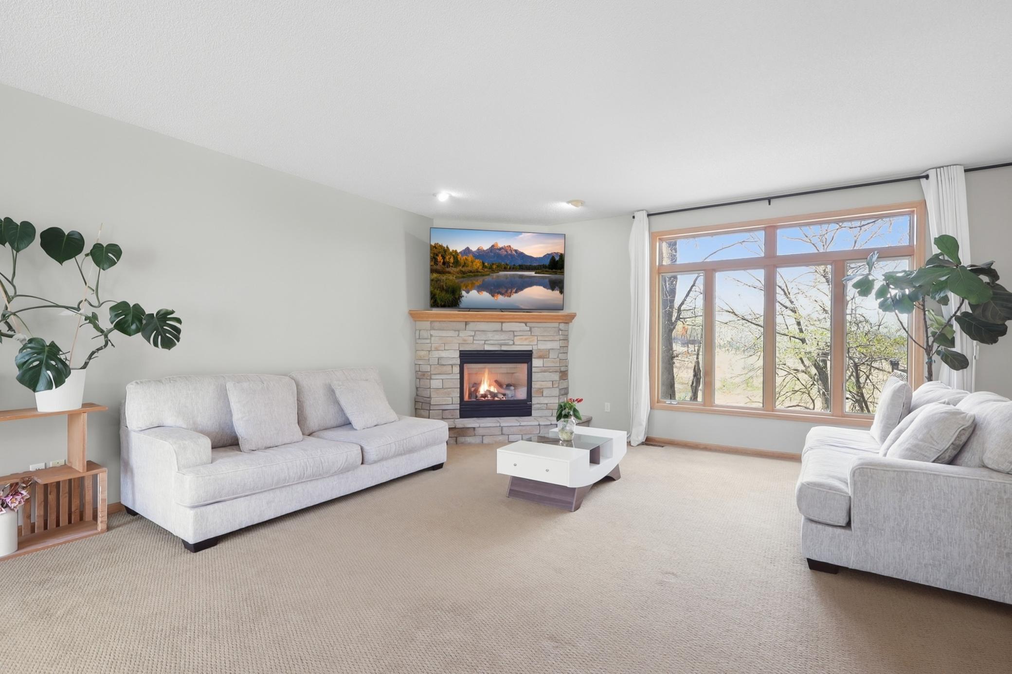 Sun filled living room with large windows overlooking peaceful wildlife views and bringing in tons of natural light throughout the day.