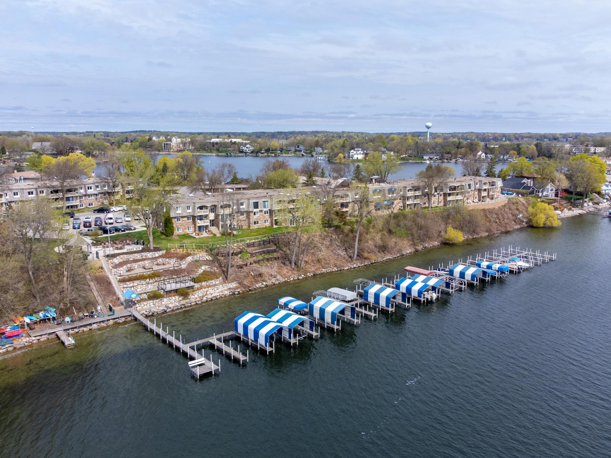 700 ft of shoreline, a sandy swim beach, community dock, lakeside patios with grills and gazebo, a lift for accessibility, kayak storage, and a rooftop Crow’s Nest deck with sweeping panoramic lake views