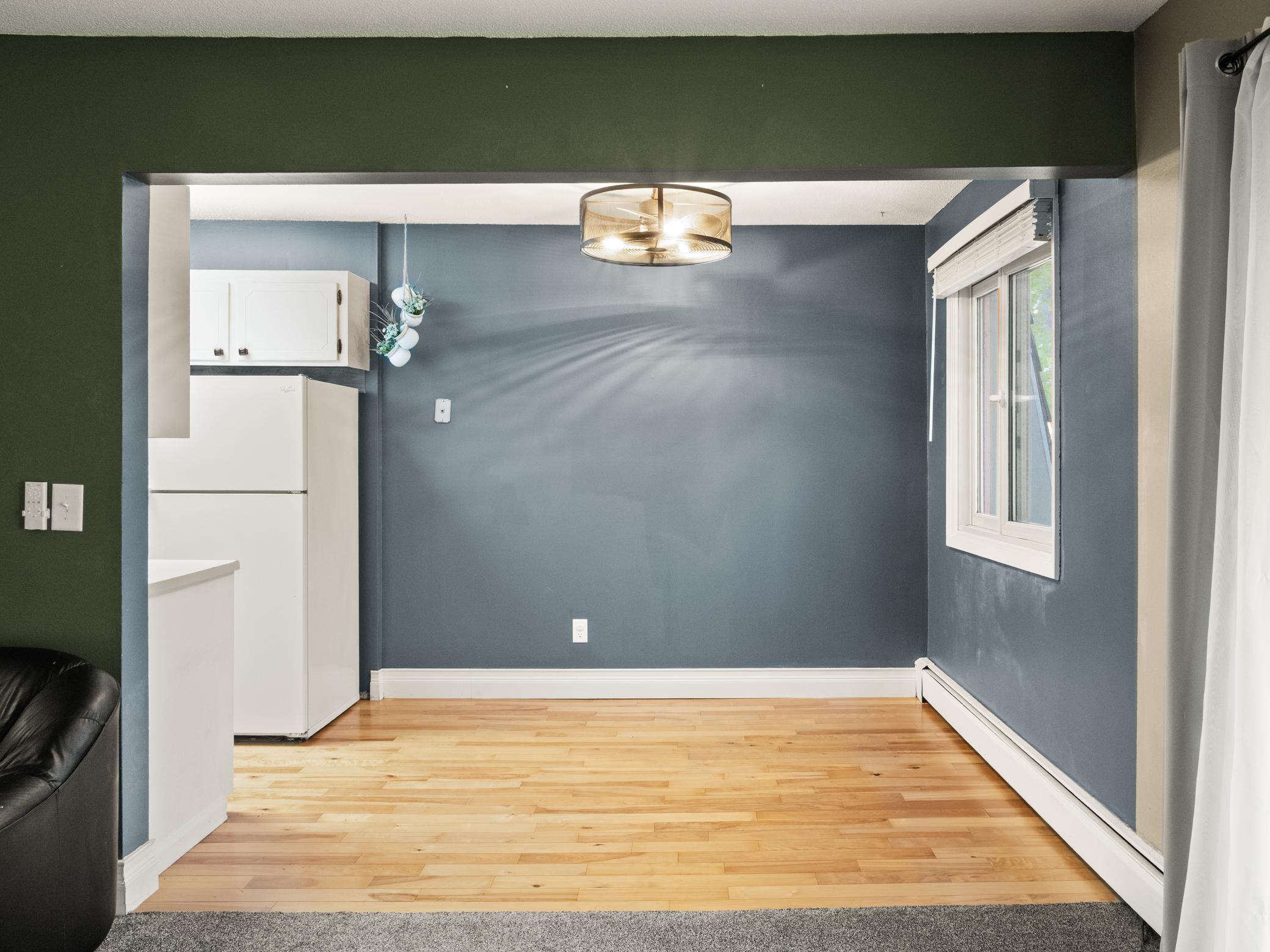 Dining room with wood flooring opens to kitchen and living room