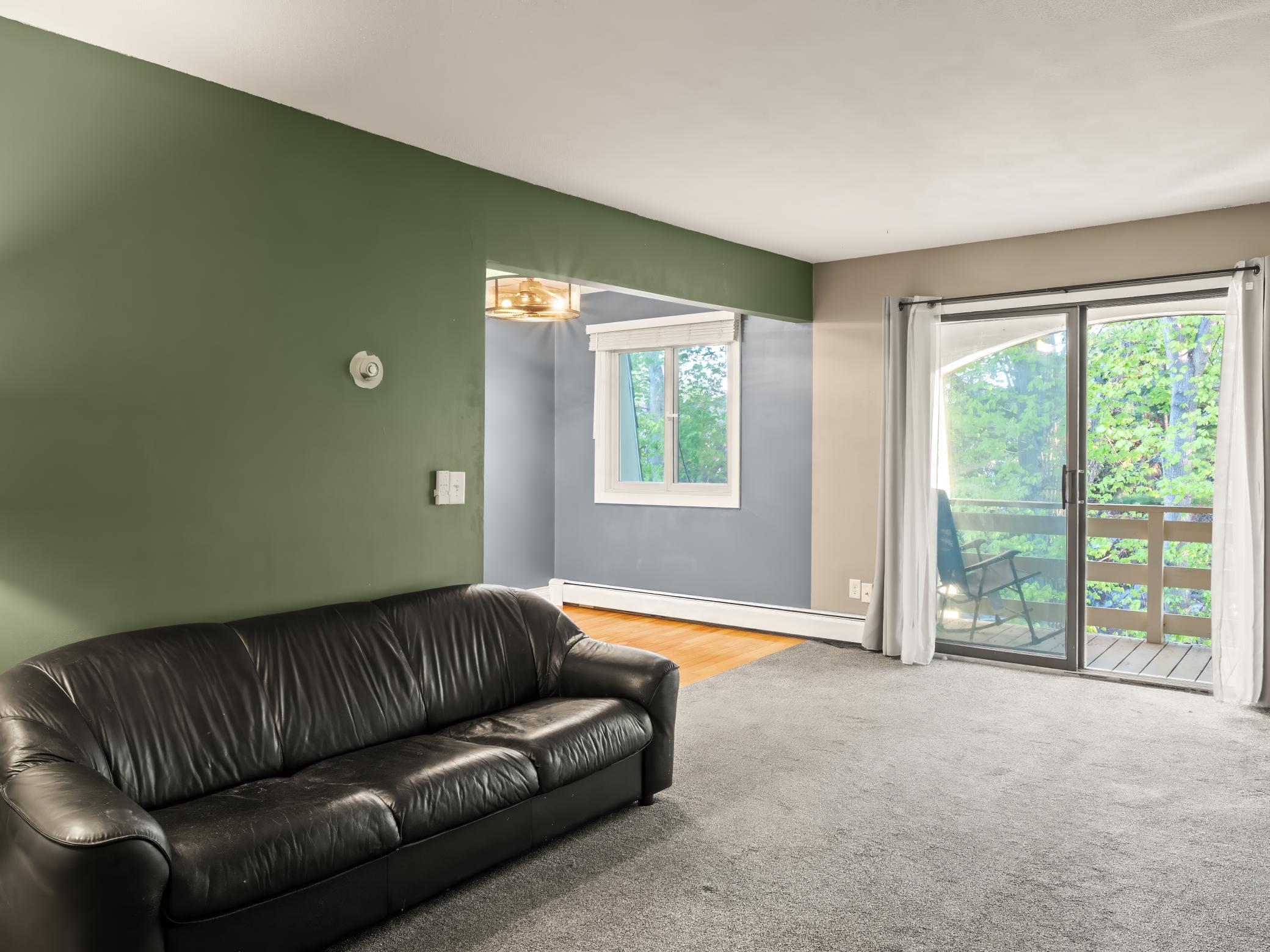 Spacious living room with beautiful views of the treetops.