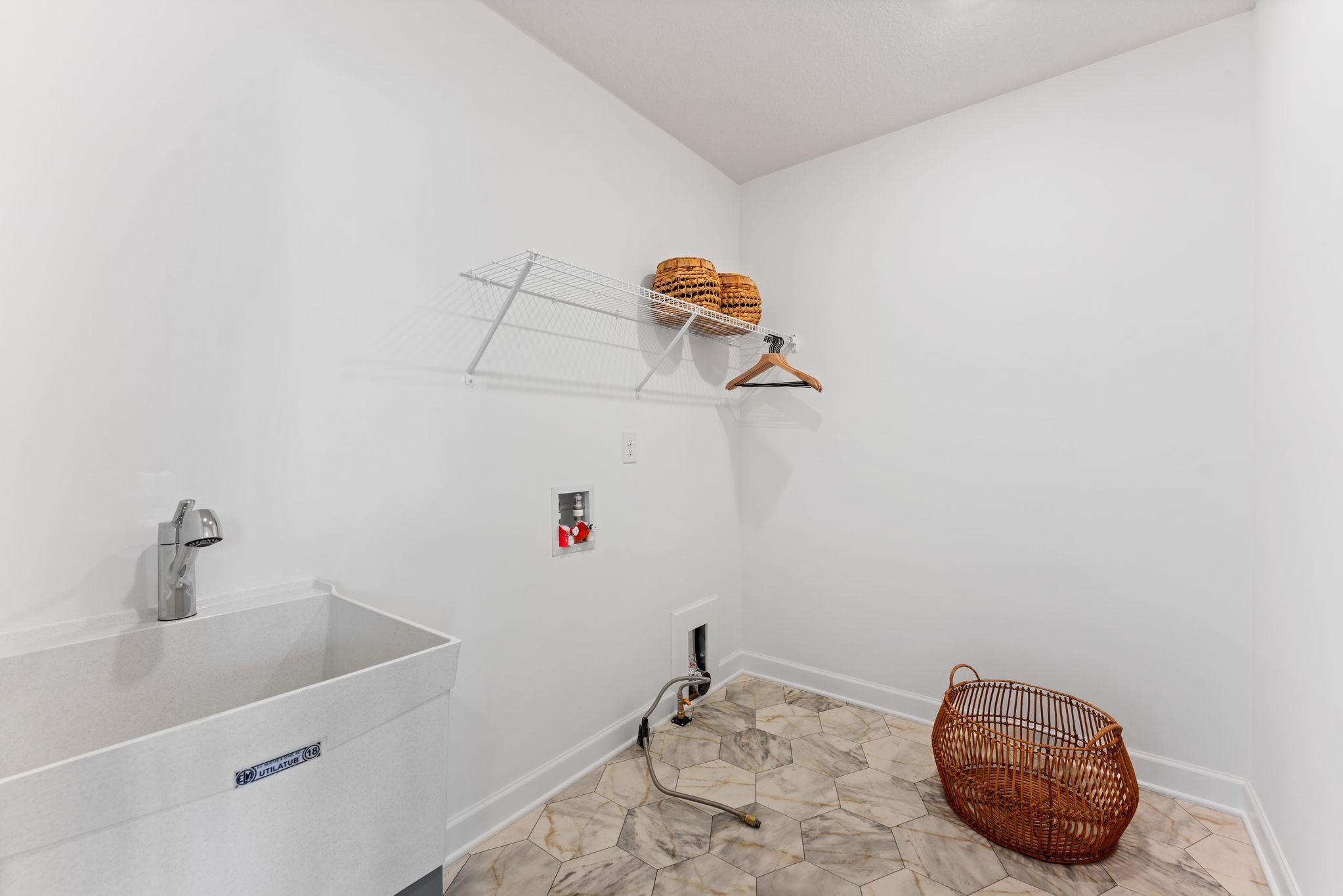 The laundry room will simplify chore days with an overhead shelf and washer-dryer connections.