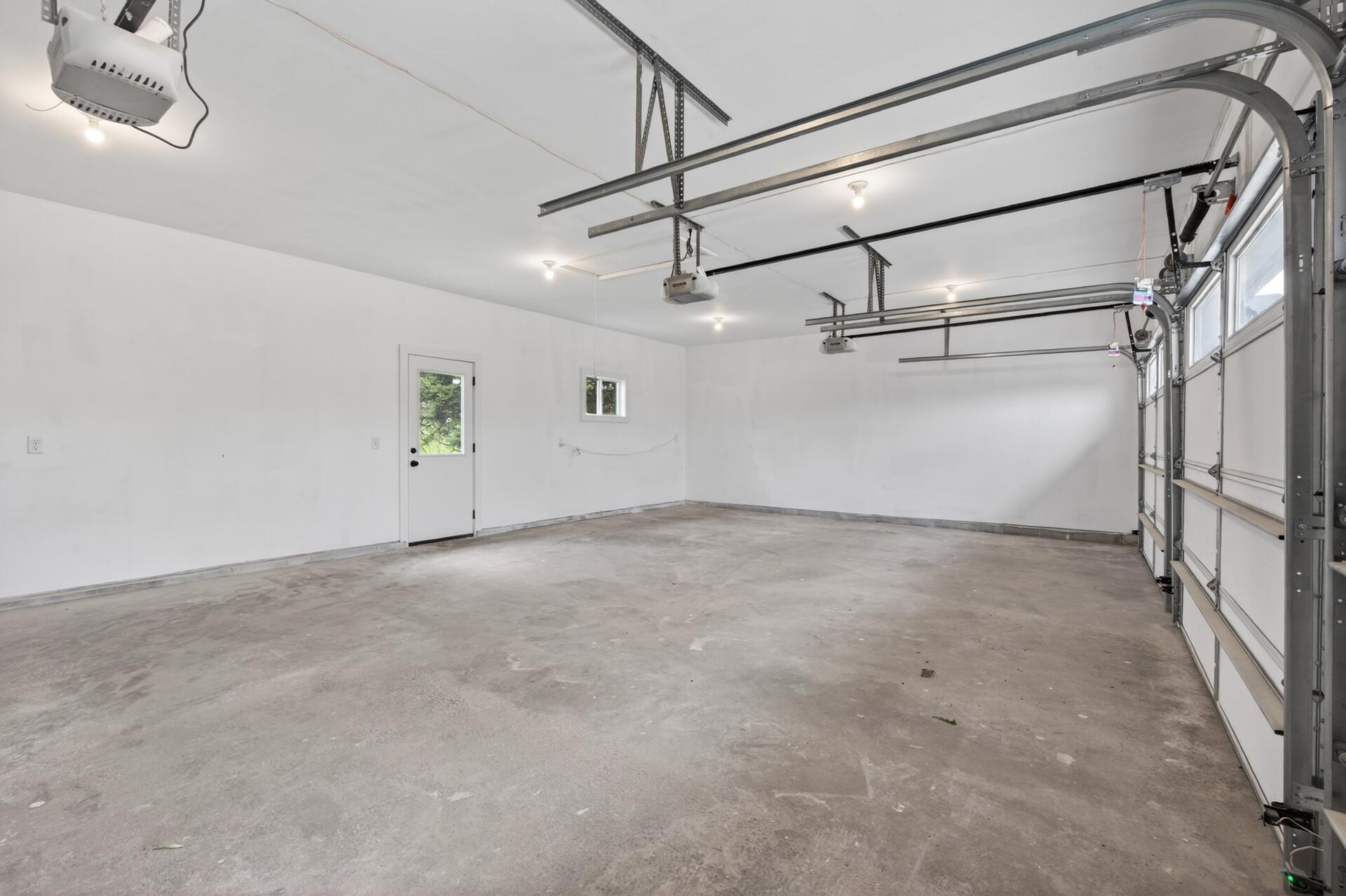 Fully insulated and sheetrocked oversized 33' x 20' three-car garage featuring a convenient service door and additional pull-down attic storage. Three separate garage doors provide added convenience and ease for parking and access.