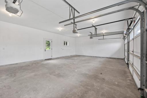 Fully insulated and sheetrocked oversized 33' x 20' three-car garage featuring a convenient service door and additional pull-down attic storage. Three separate garage doors provide added convenience and ease for parking and access.