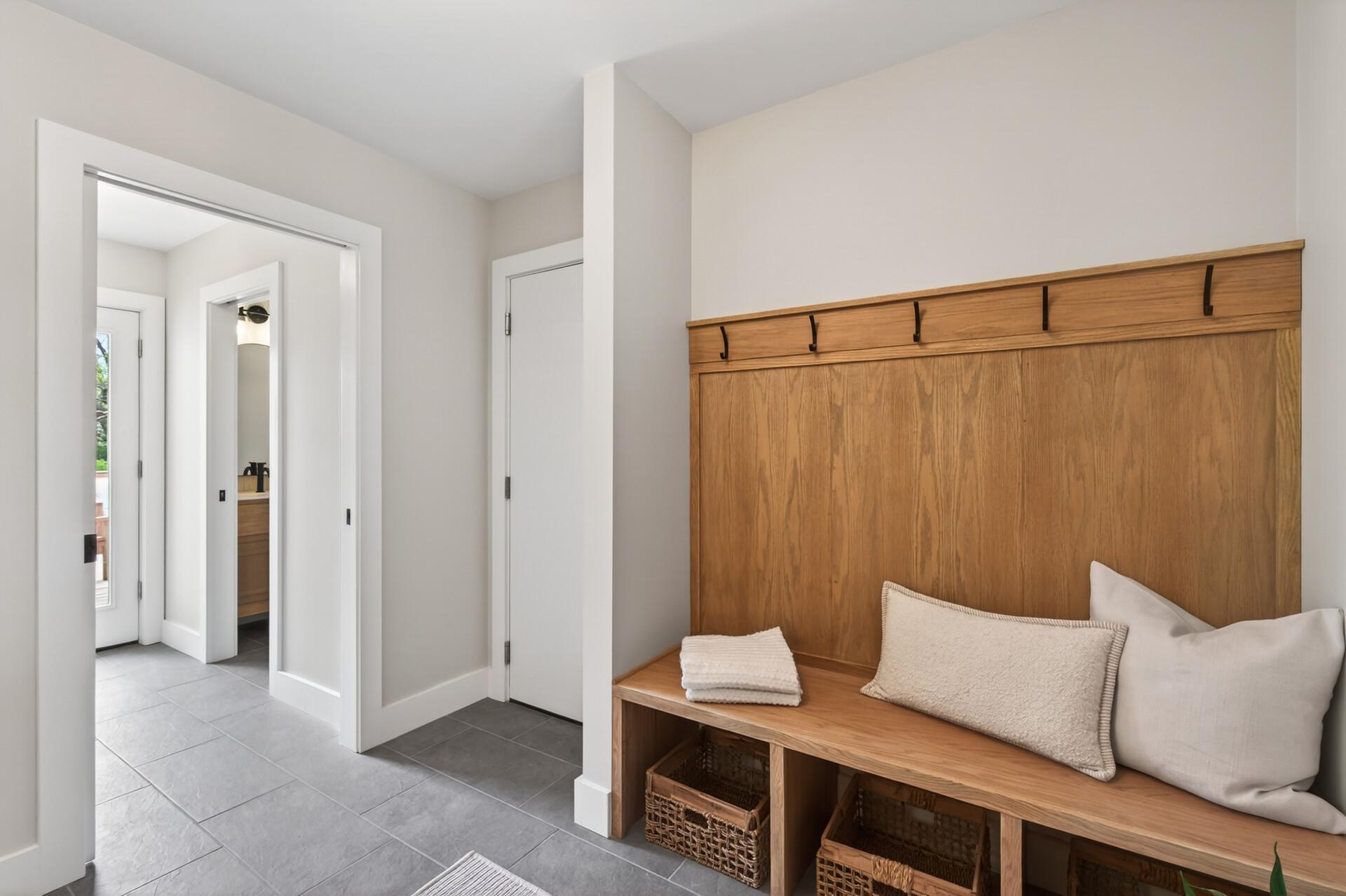 Designed with both style and functionality in mind, the entry-level foyer features a built-in bench with storage and convenient coat hooks for everyday organization.