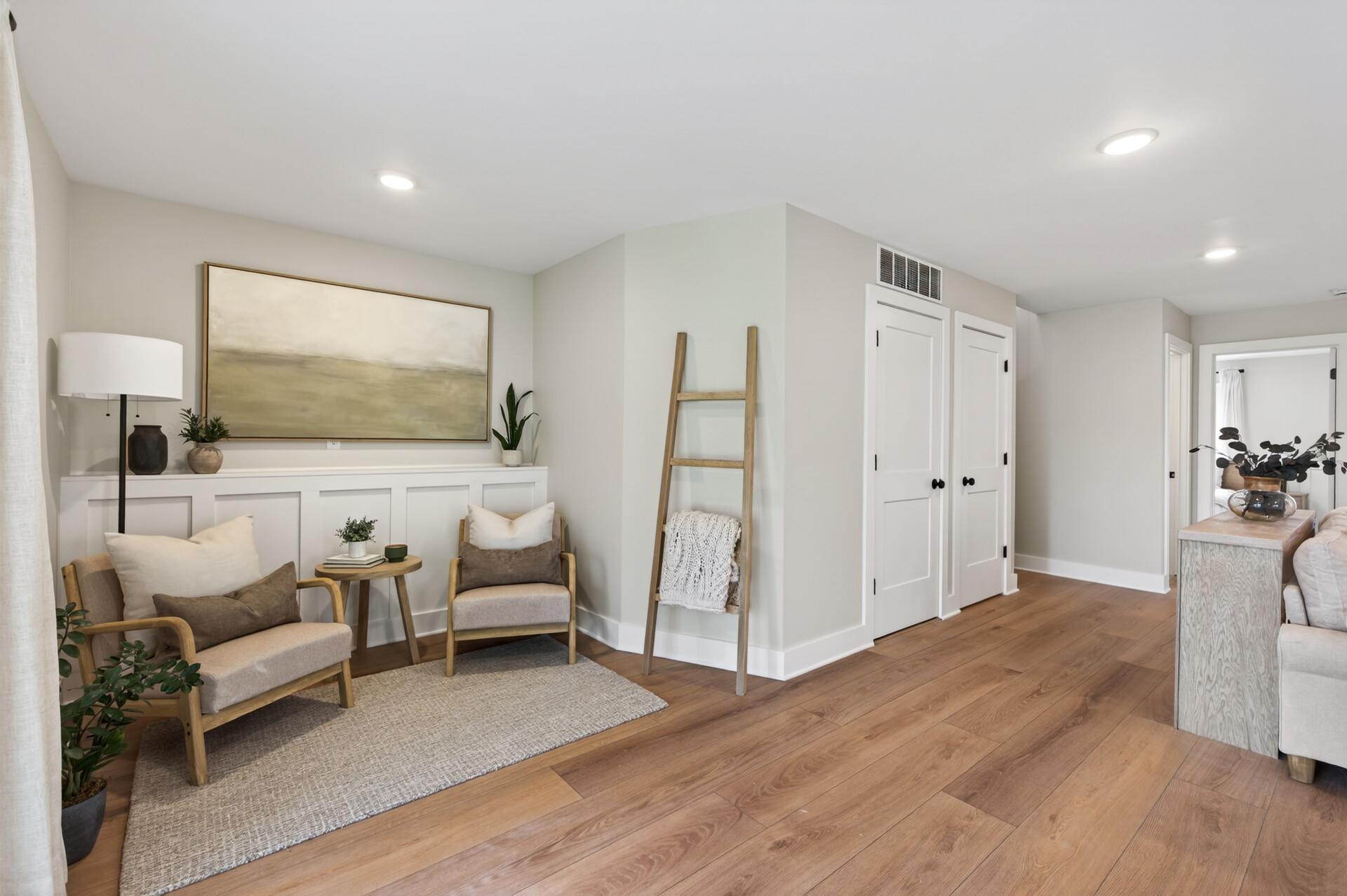 Thoughtfully designed lower level sitting area with custom wall detailing and a warm inviting feel throughout.