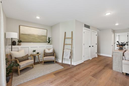 Thoughtfully designed lower level sitting area with custom wall detailing and a warm inviting feel throughout.