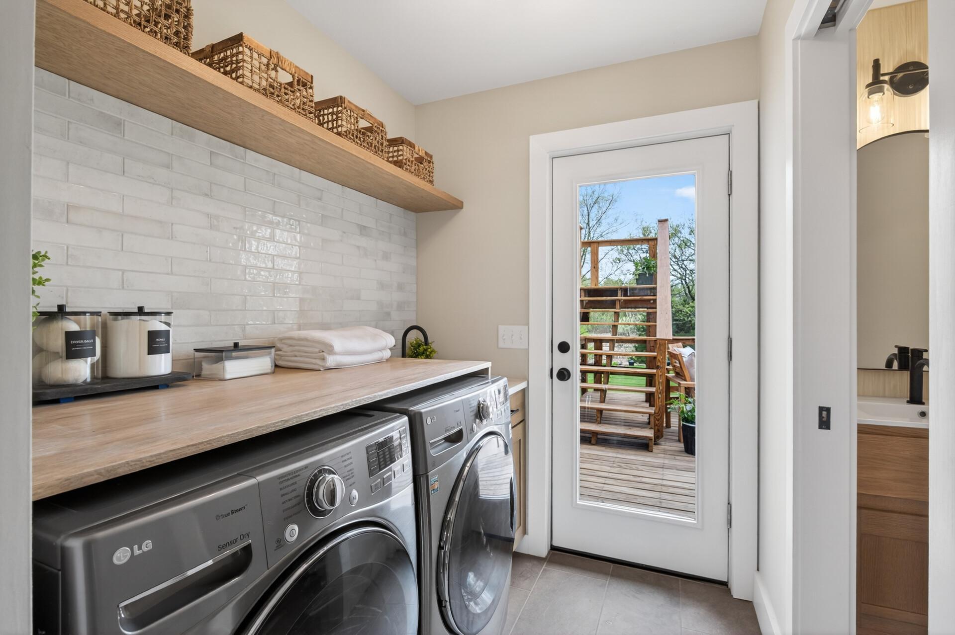 The laundry room features a folding counter, floating shelf, pocket door, & utility sink. There is also a stylish one-half bath on the main level, & direct access to the backyard deck. Both areas can be closed off with pocket doors.