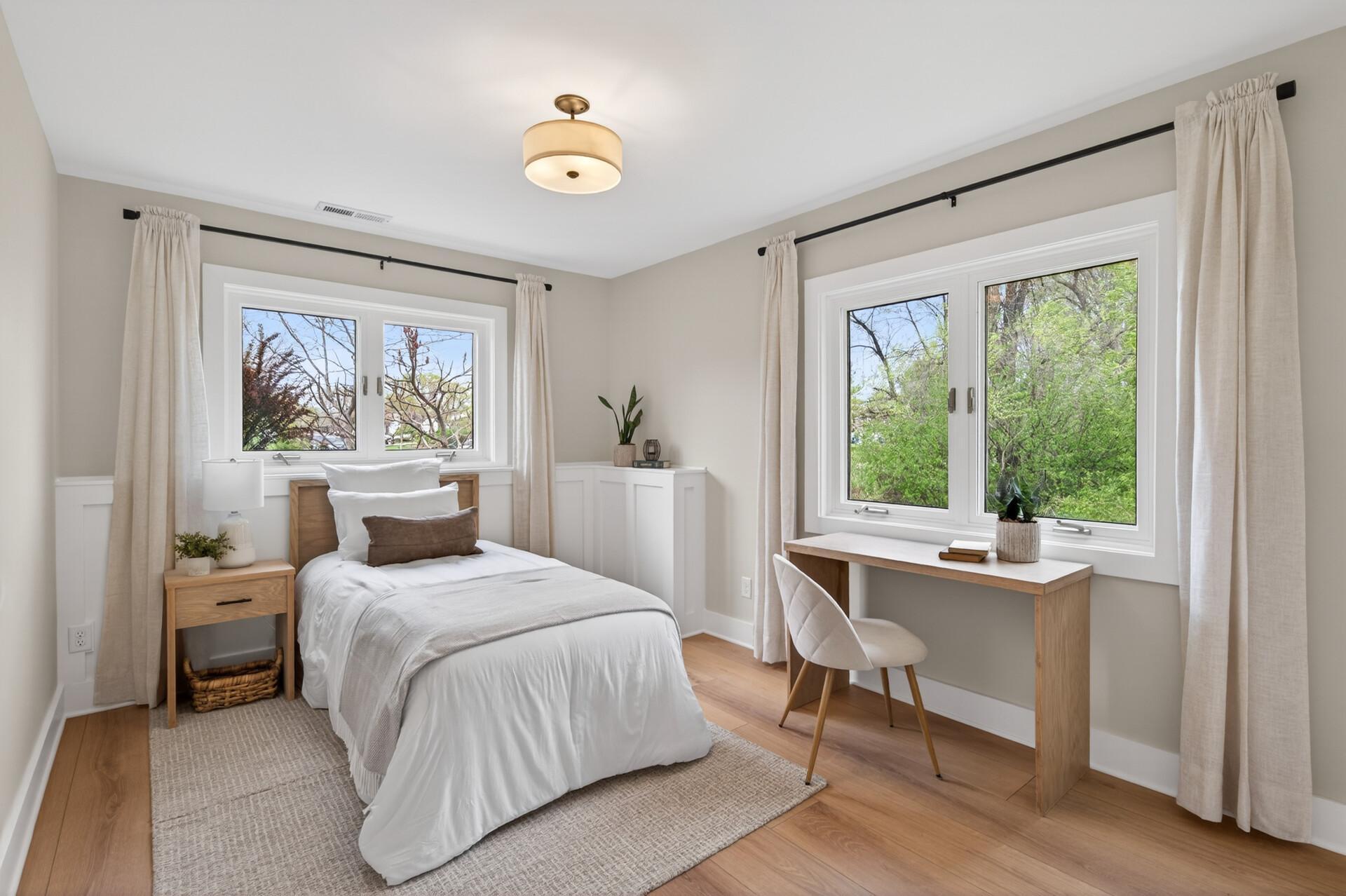 This bright lower-level bedroom includes updated flooring and solid wood closet organizers.