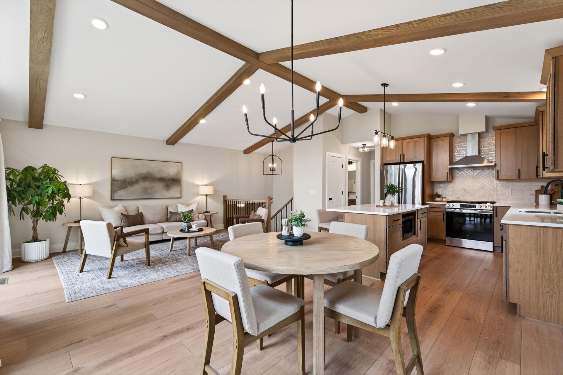 Open and airy main living space. Wide plank flooring, soaring ceilings, and striking beamed details create a warm and inviting upper-level living area designed for both everyday living and entertaining.