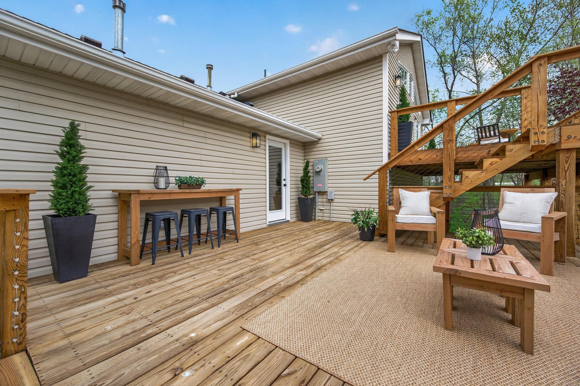 Expansive main-level deck with convenient exterior door access creates a seamless connection to the home’s outdoor living space.