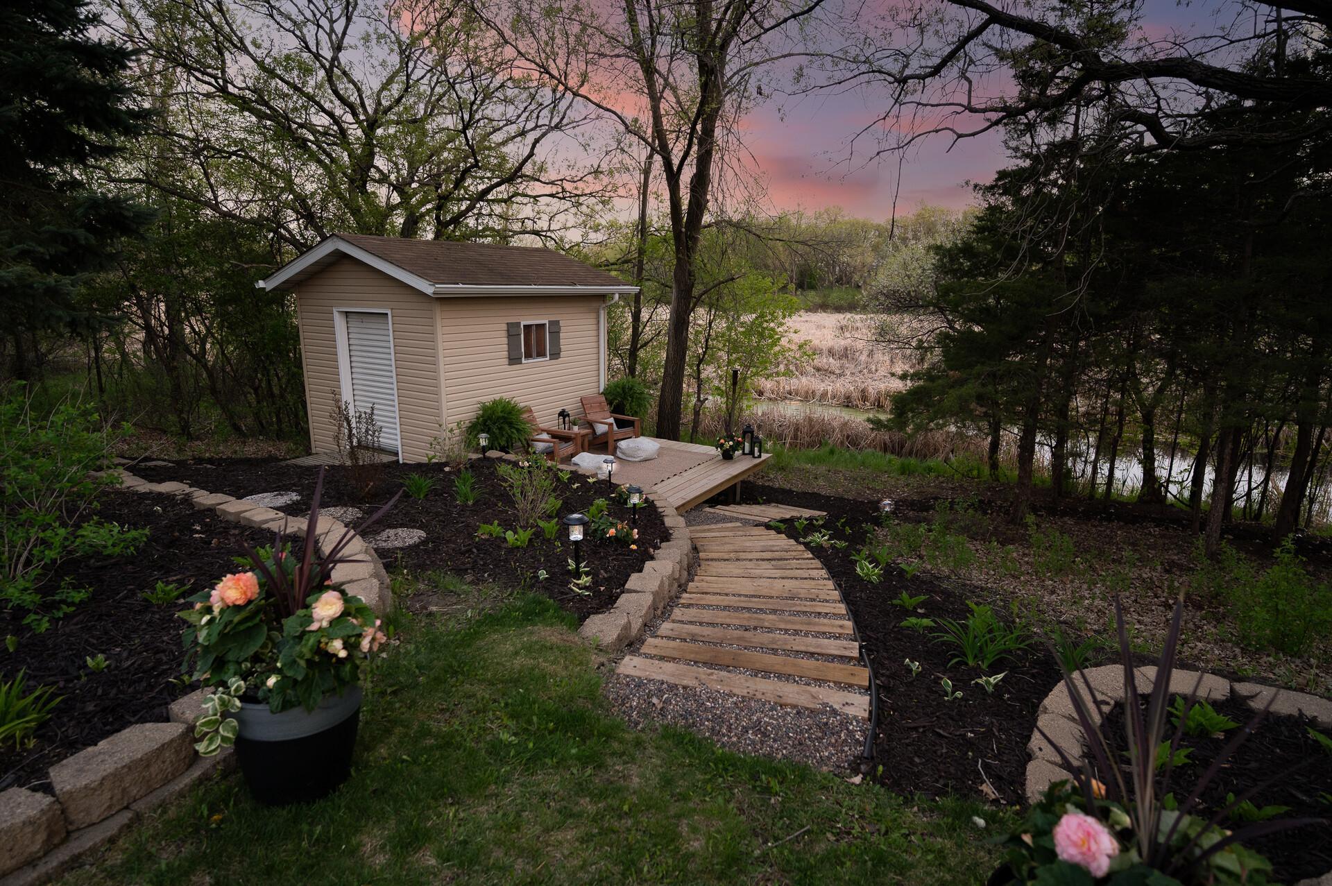Follow the beautifully landscaped pathway to the backyard storage shed, offering convenient additional storage space for your outdoor and seasonal needs.