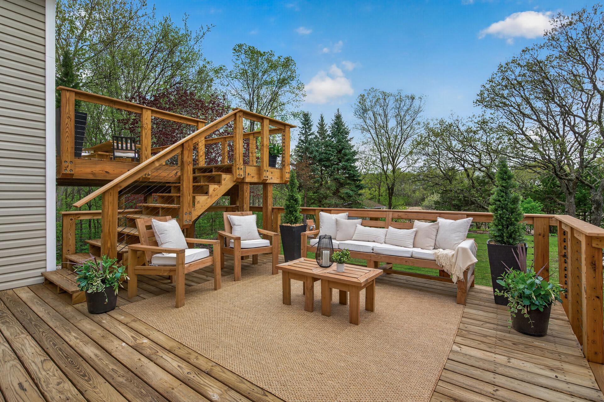 The impressive two-tier deck offers multiple spaces for entertaining, dining and relaxing while overlooking the beautifully landscaped backyard and pond setting.