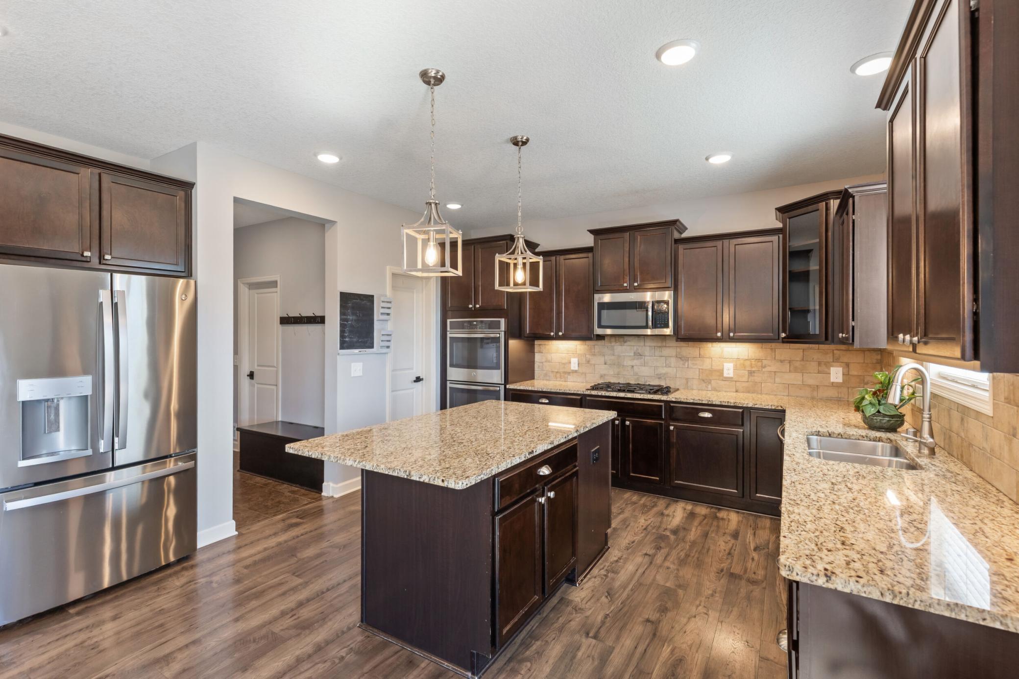 Kitchen has beautiful cabinetry, stone back splash and granite countertops.