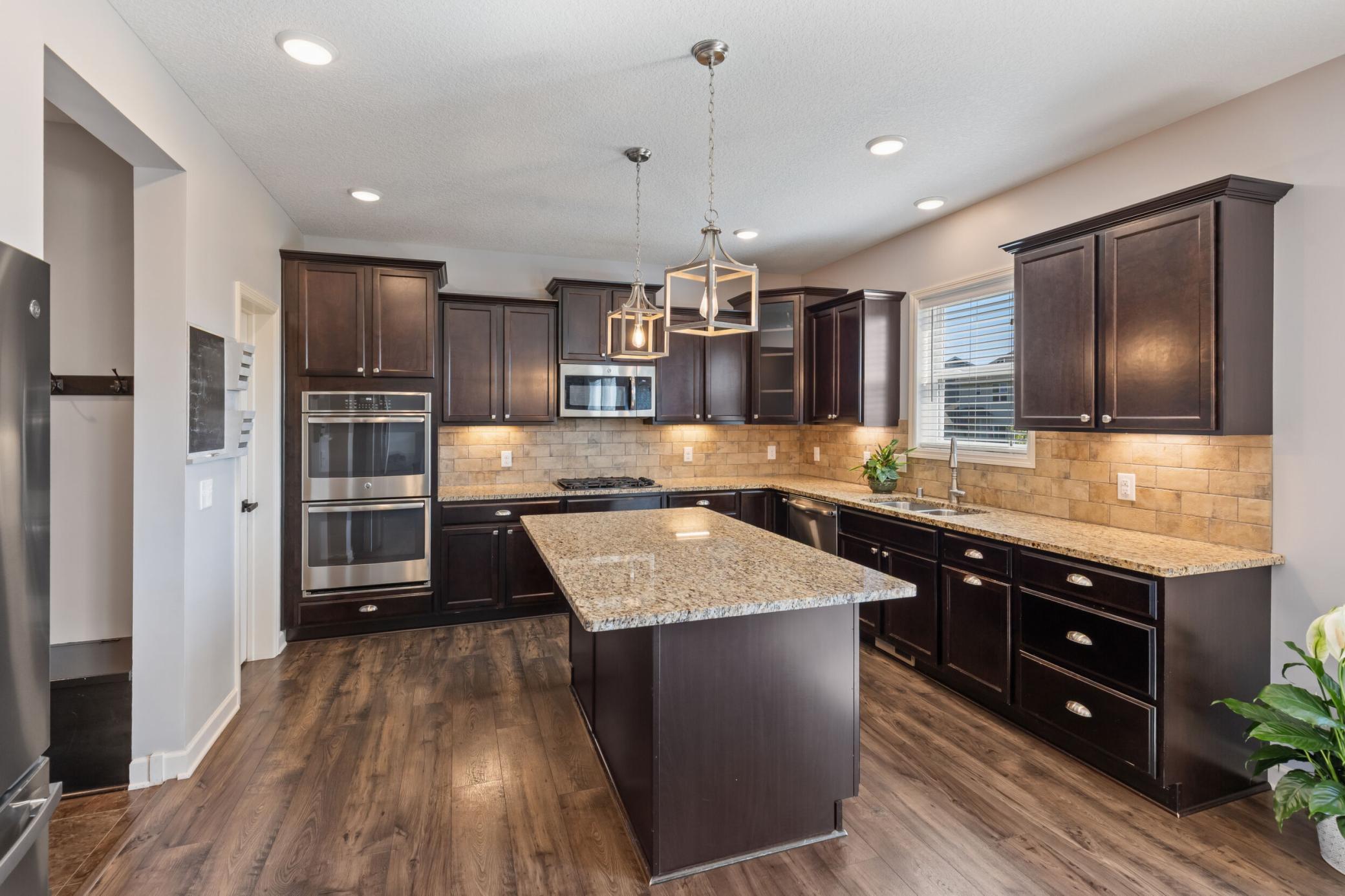 Look at all of the counter space and storage. Stainless steel appliances, Double ovens, microwave, gas range.