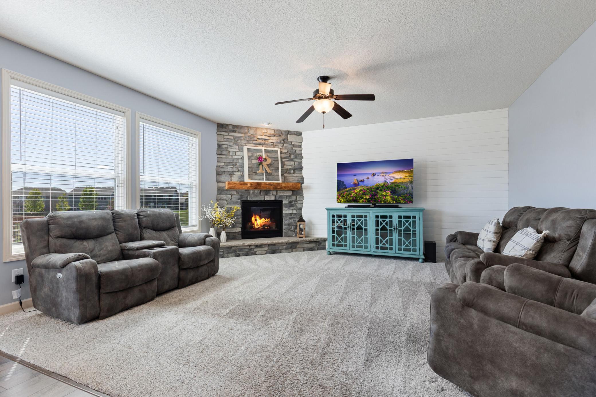 Gorgeous custom stone surround gas fireplace, such a bright and inviting room.