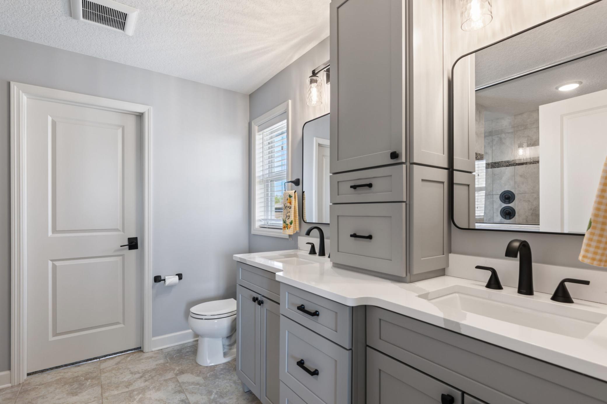 Primary bath with custom vanity and dual sinks. Awesome walk in closet.