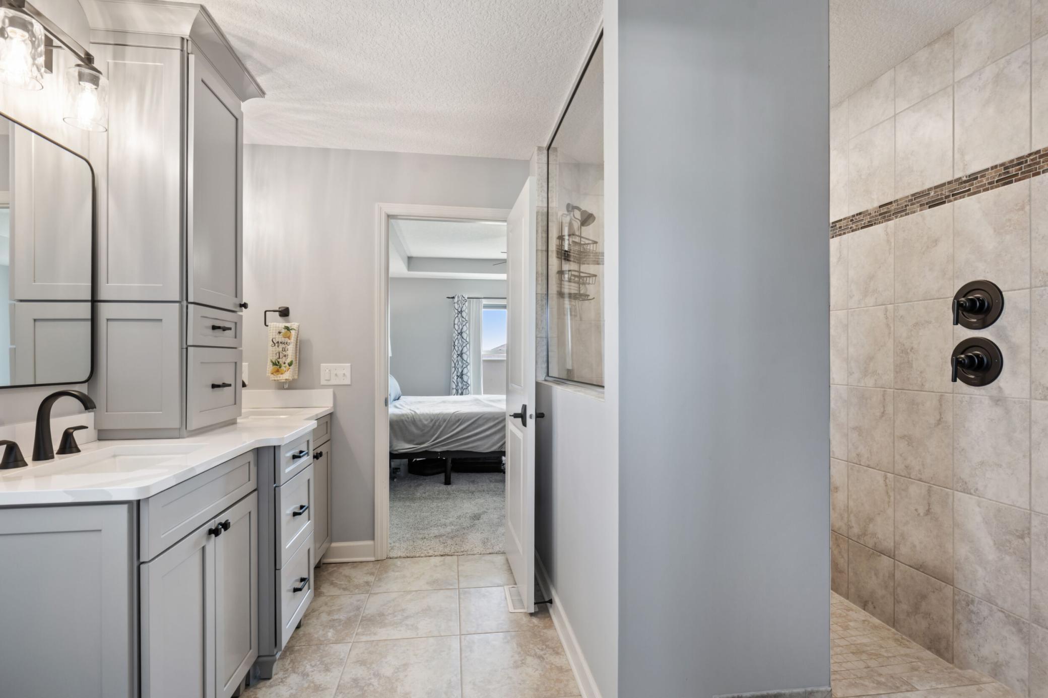 Primary bath with ceramic tile flooring and shower surround