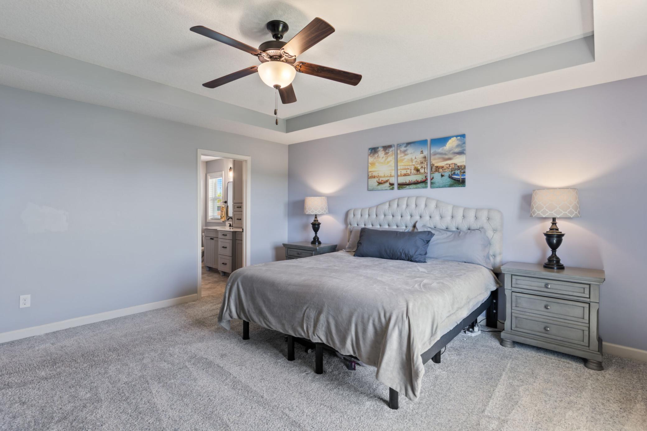 Primary bedroom has a box ceiling with fan.