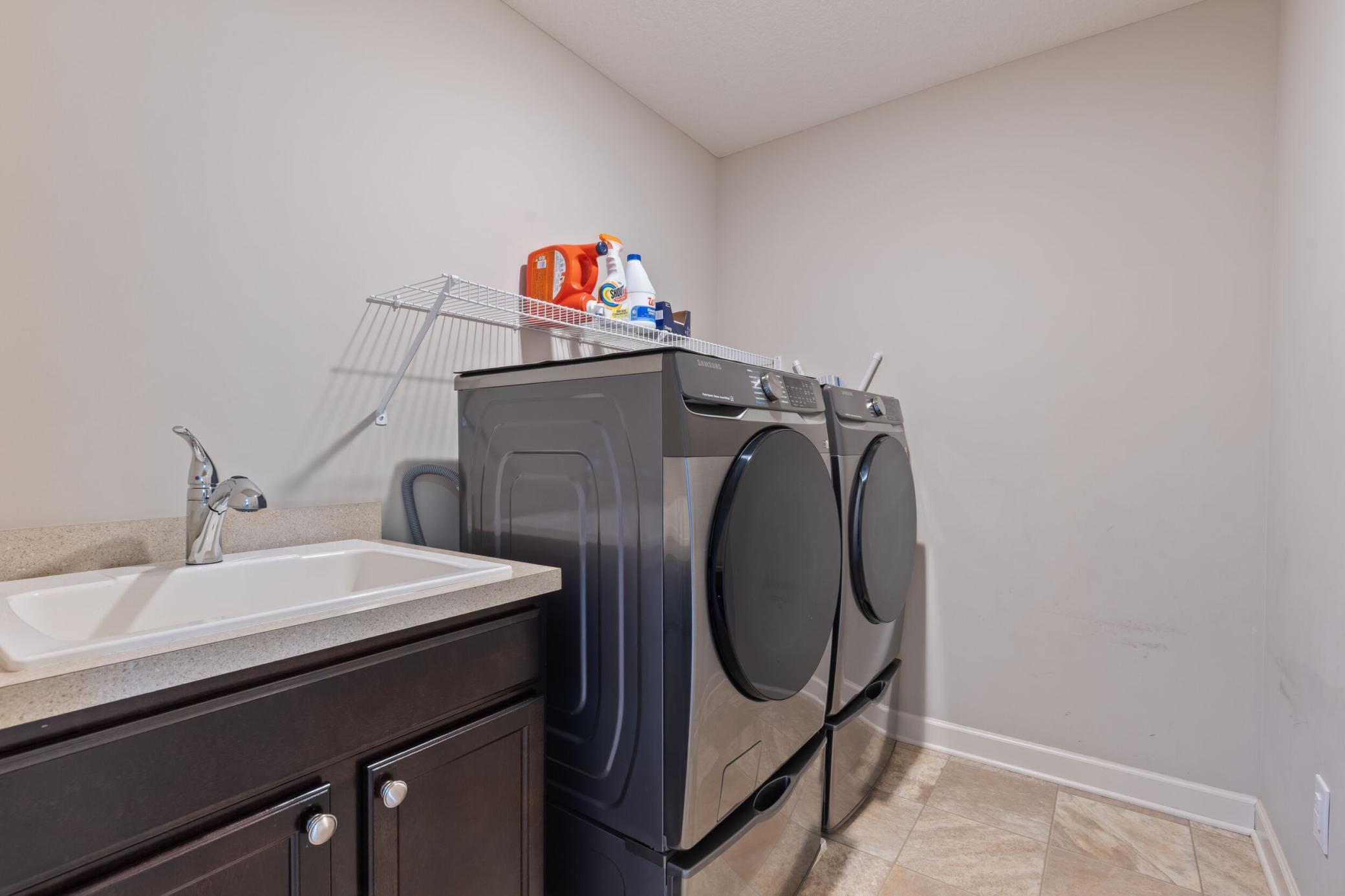 Upper level Laundry room with sink and cabinets.