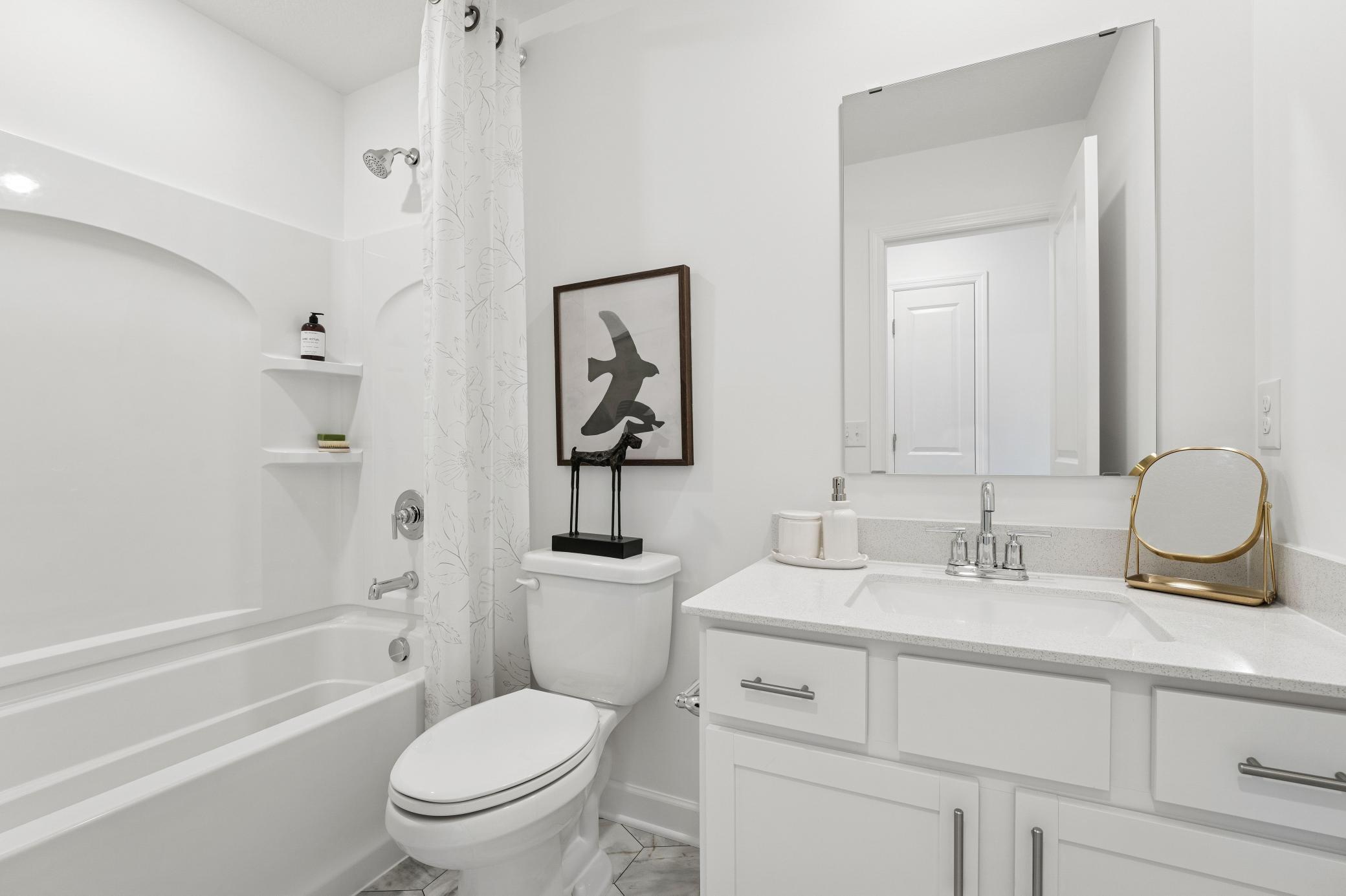 This full-sized bathroom is near the secondary bedrooms and features a single vanity and shower-tub combination.