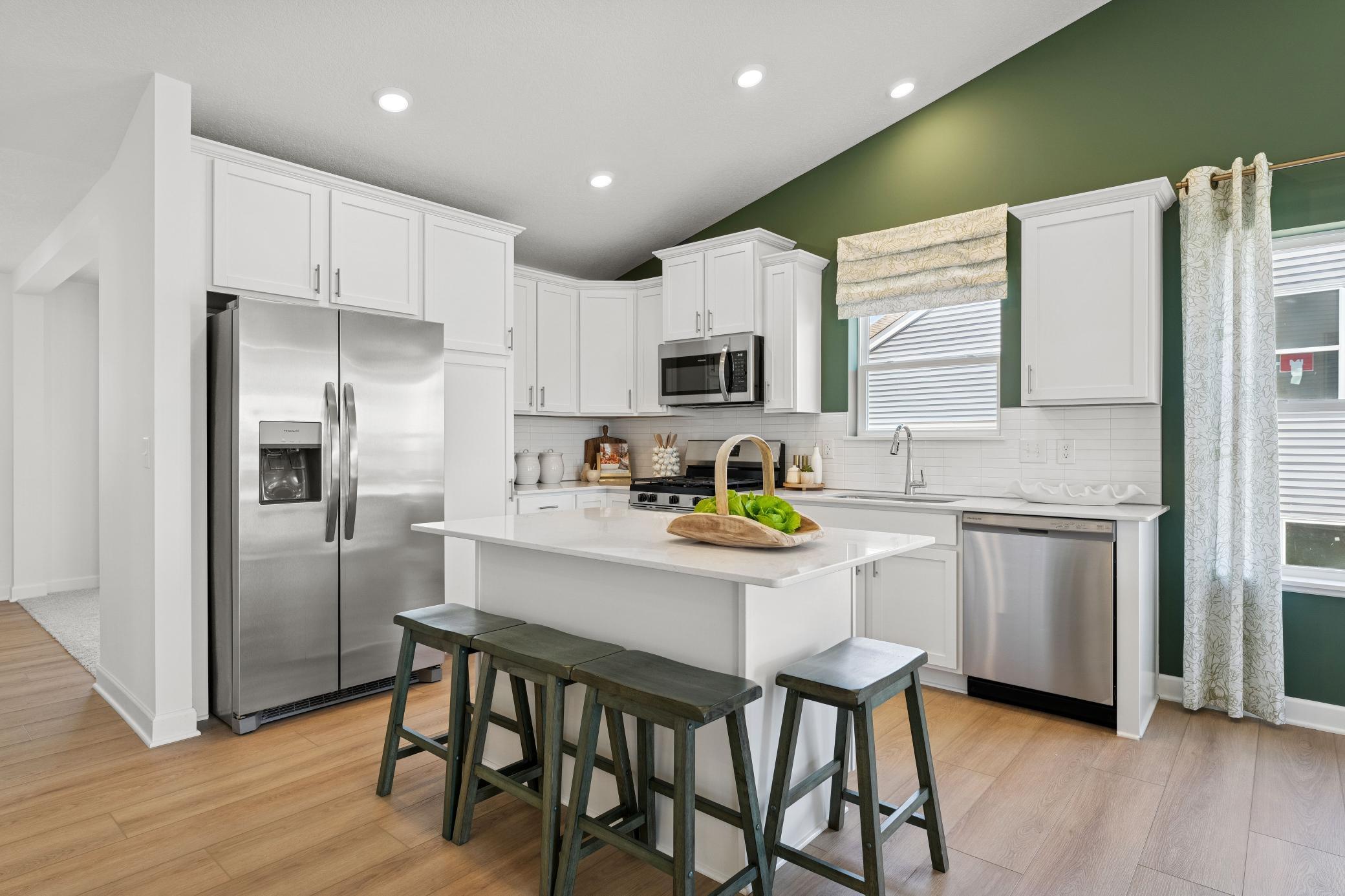 The chef-inspired kitchen showcases an elevated design, equipped with new cutting-edge appliances and a center island that adds bar-style seating.