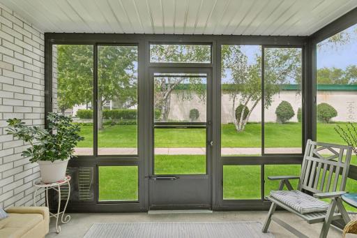 Screened/combination windows on this enclosed patio. Beautiful green spaces beyond.