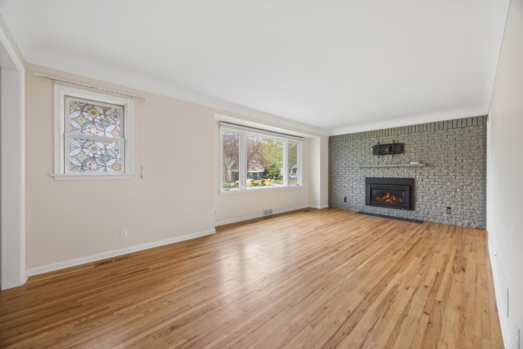 Spacious Living room features large picture window with automatic shades and gas fireplace