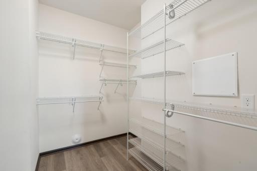 Large primary bedroom walk-in closet with extensive shelving and organized storage system.