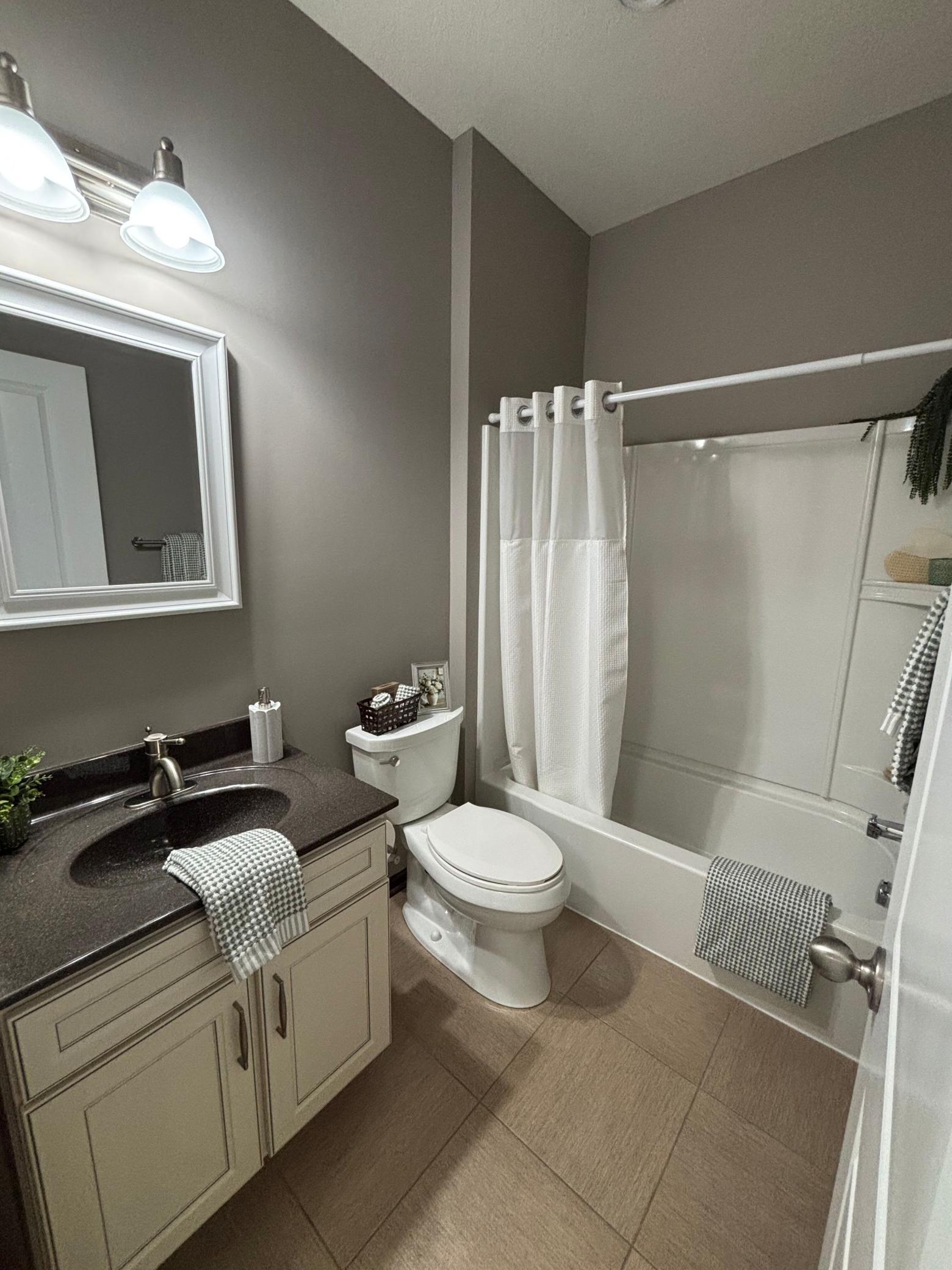 Main floor full bathroom featuring tub/shower combo and neutral finishes.
