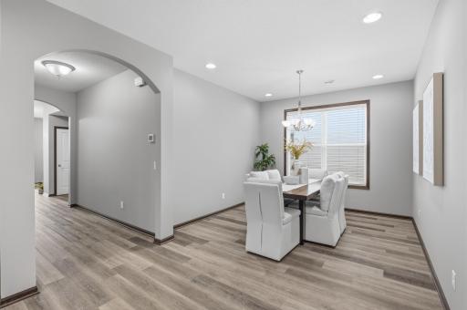 Spacious dining area with plenty of room for gathering and entertaining, complemented by a large window for natural light.