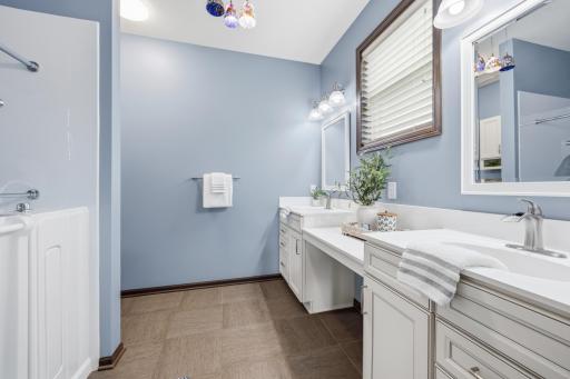 Primary bath with dual vanity sink and makeup station.