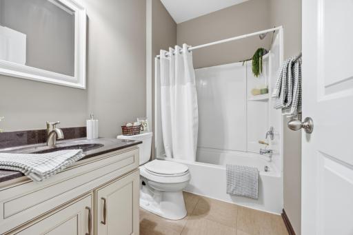 Main floor full bathroom featuring tub/shower combo and neutral finishes.