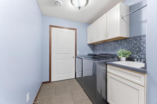 Convenient laundry room with high-end washer and dryer, utility sink, cabinetry and utility room access. You'll also find a pantry and coat/storage closet.