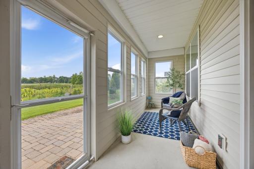 Cozy and bright 3-season porch with brand new windows overlooking the scenic backyard.