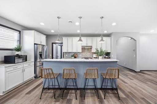 Beautifully appointed kitchen with abundant cabinetry with pullouts, tile backsplash, and gas range and beautiful granite countertops.