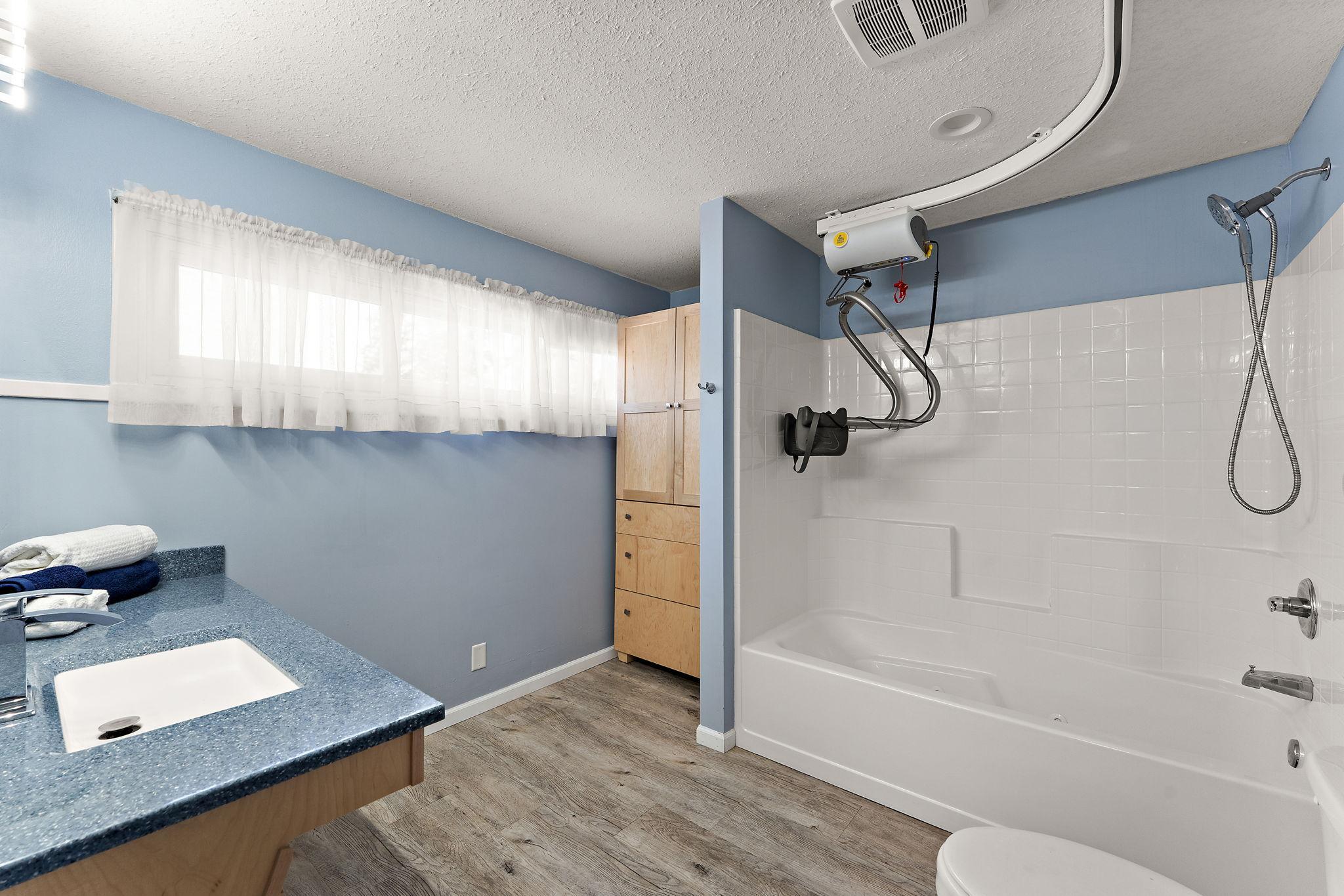 The primary bath has an over sized jetted tub & roll under sink. Pictured is the lift, which can be removed.