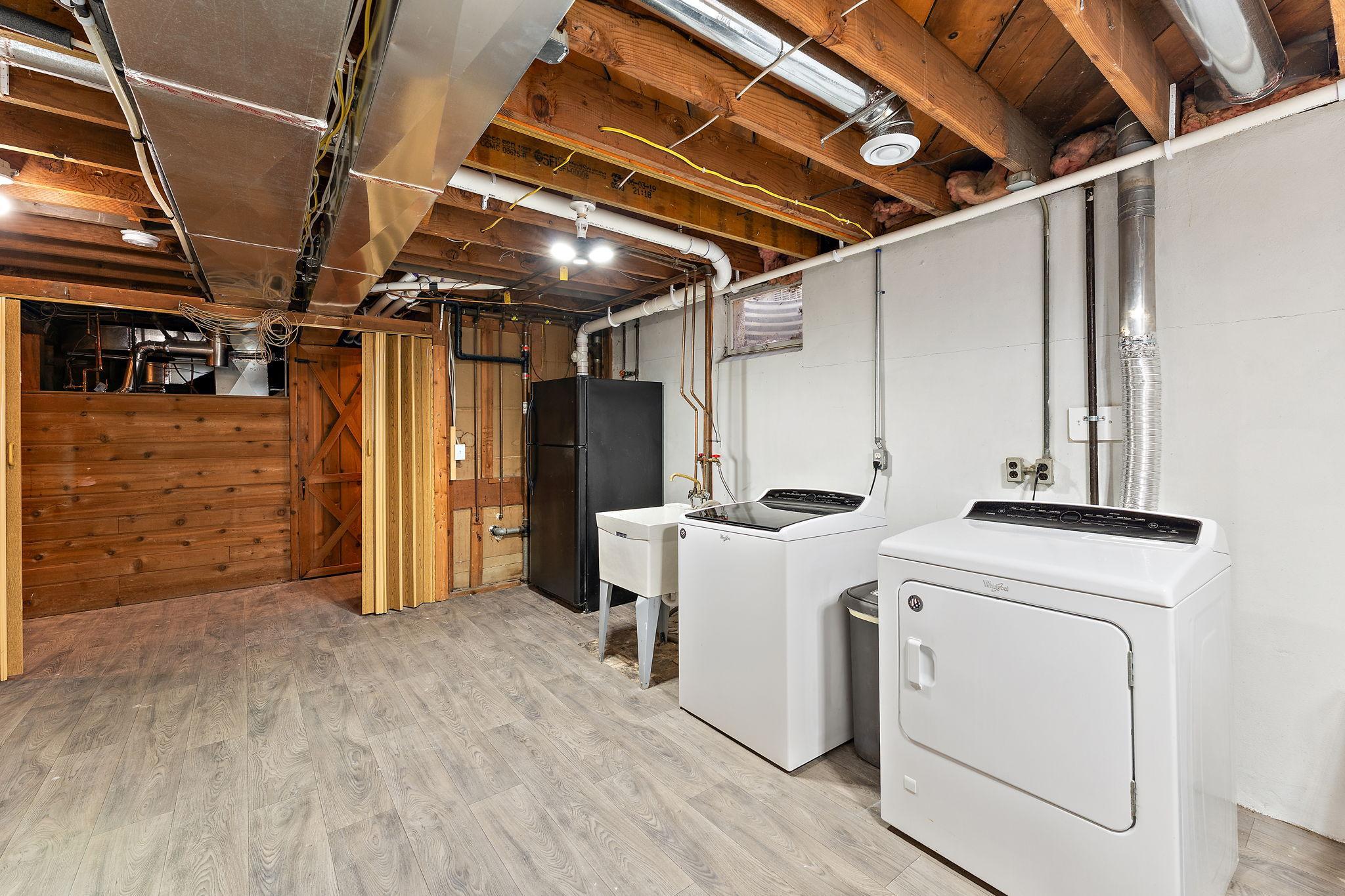 Laundry room with extra fridge.
