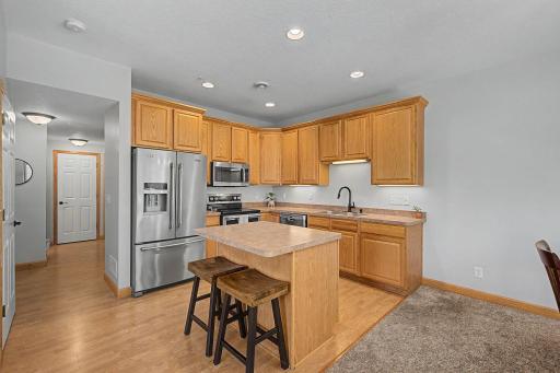 The kitchen features stainless steel appliances, recessed lighting, a center island and ample kitchen cabinet space.