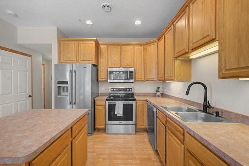 Kitchen with view of the hall leading to the garage, utility room and an extra pantry for additional storage space.