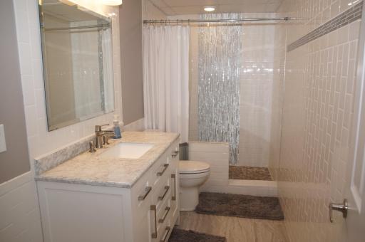 Recently Remodeled Lower Level a\All Tile Bath with Quartz Vanity, Updated Fixtures and Artistic Waterfall Tile Design in Shower!