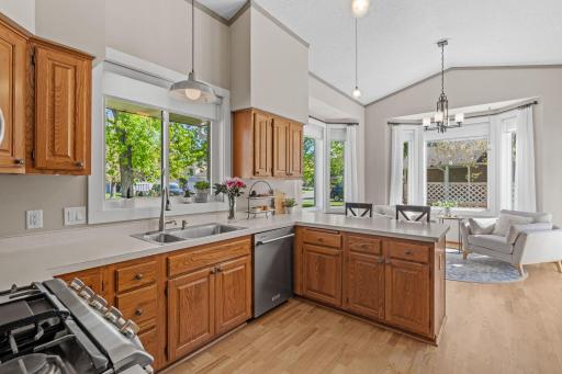 The kitchen is open and bright with large windows and a vaulted ceiling.