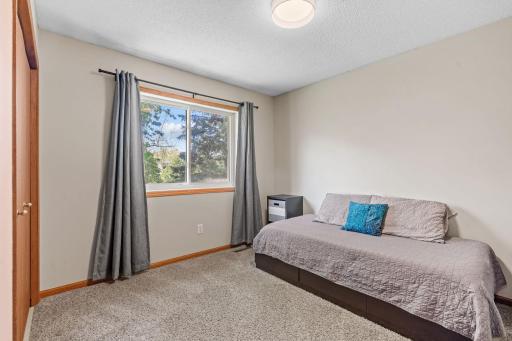 3rd bedroom on the upper level, backyard views.