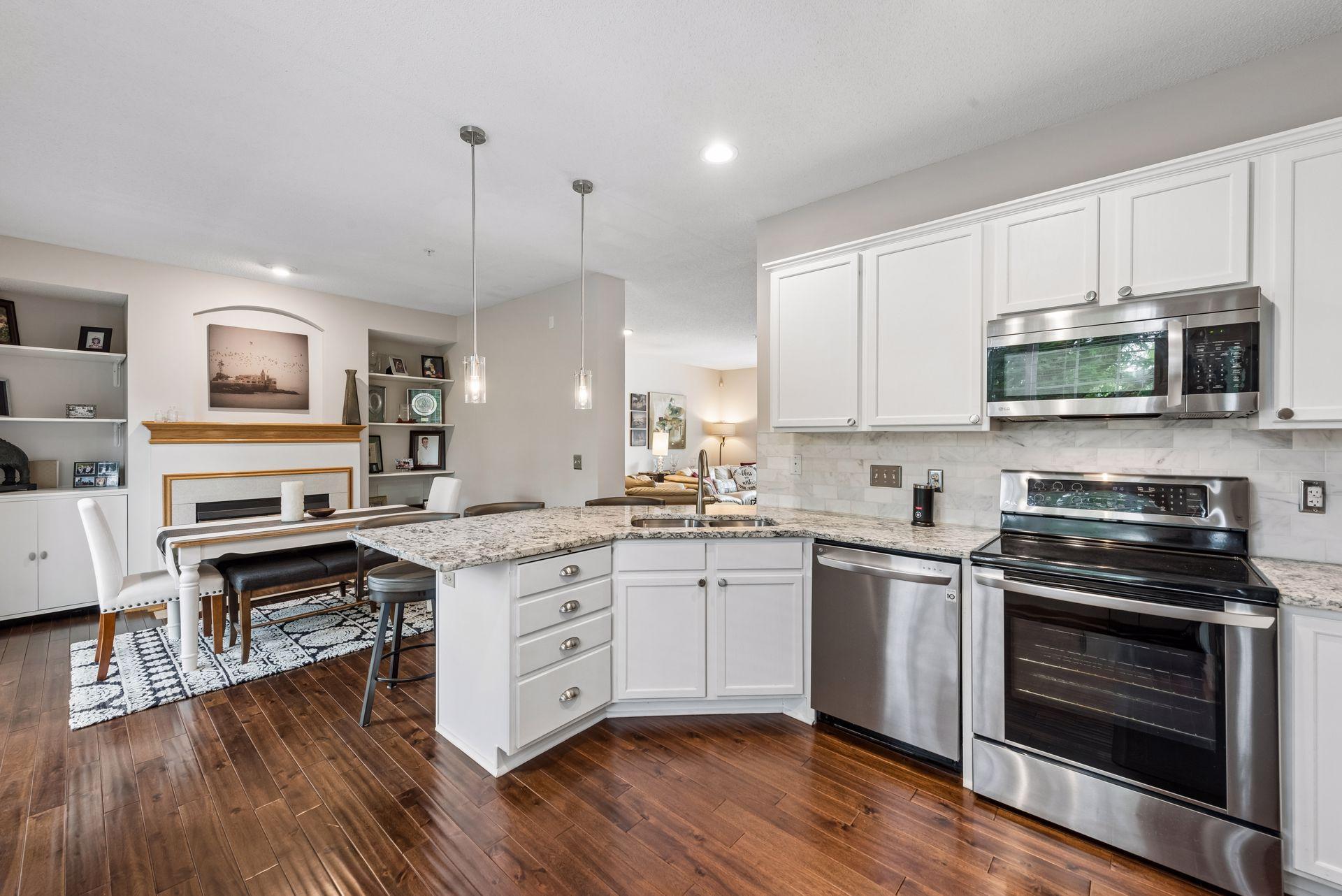 The kitchen has been redone and features granite countertops, an extended breakfast bar, tile backsplash, tasteful white cabinets, and stainless appliances.
