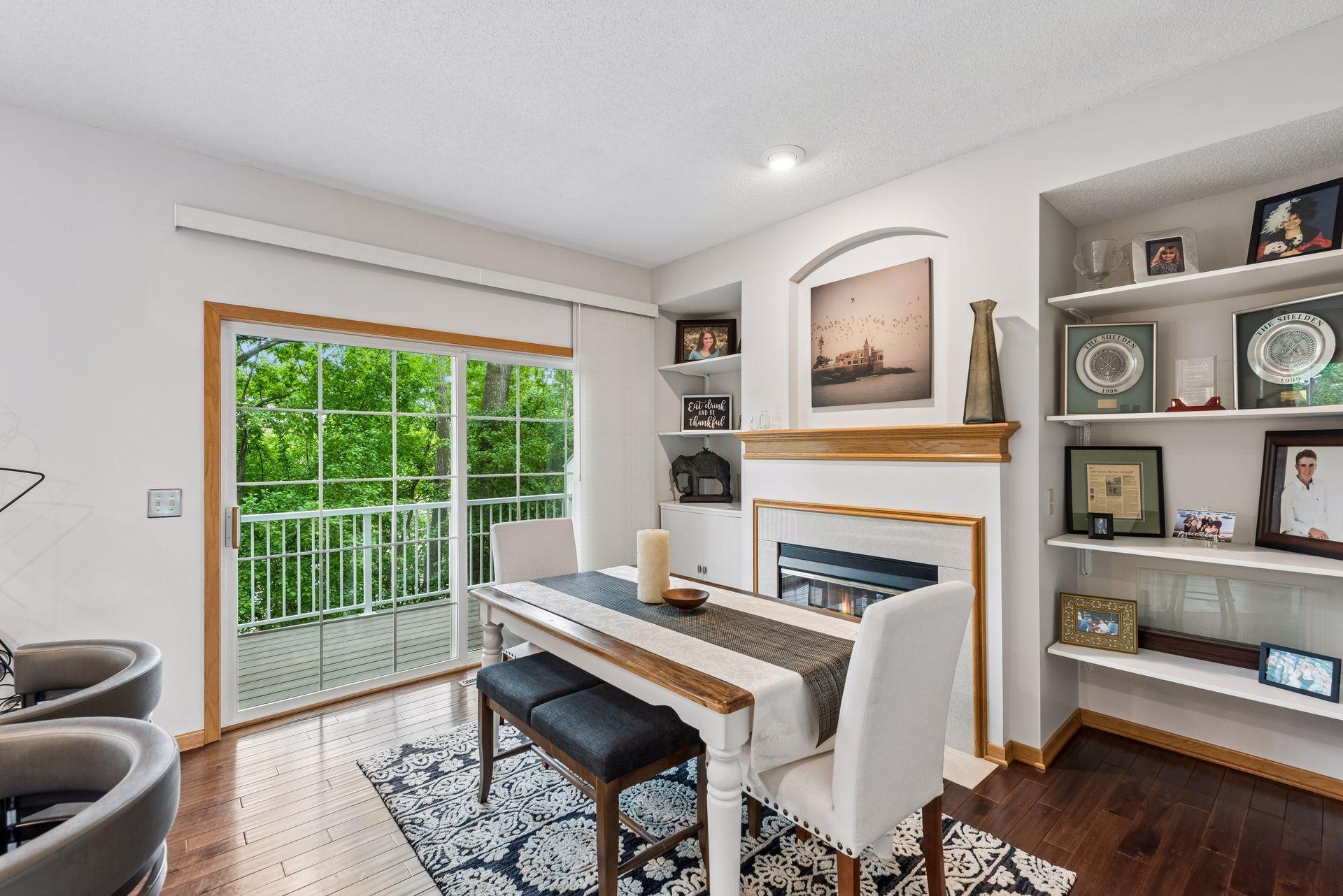 Dining room is open to the kitchen and features a gas fireplace with flanking shelving & cabinets.