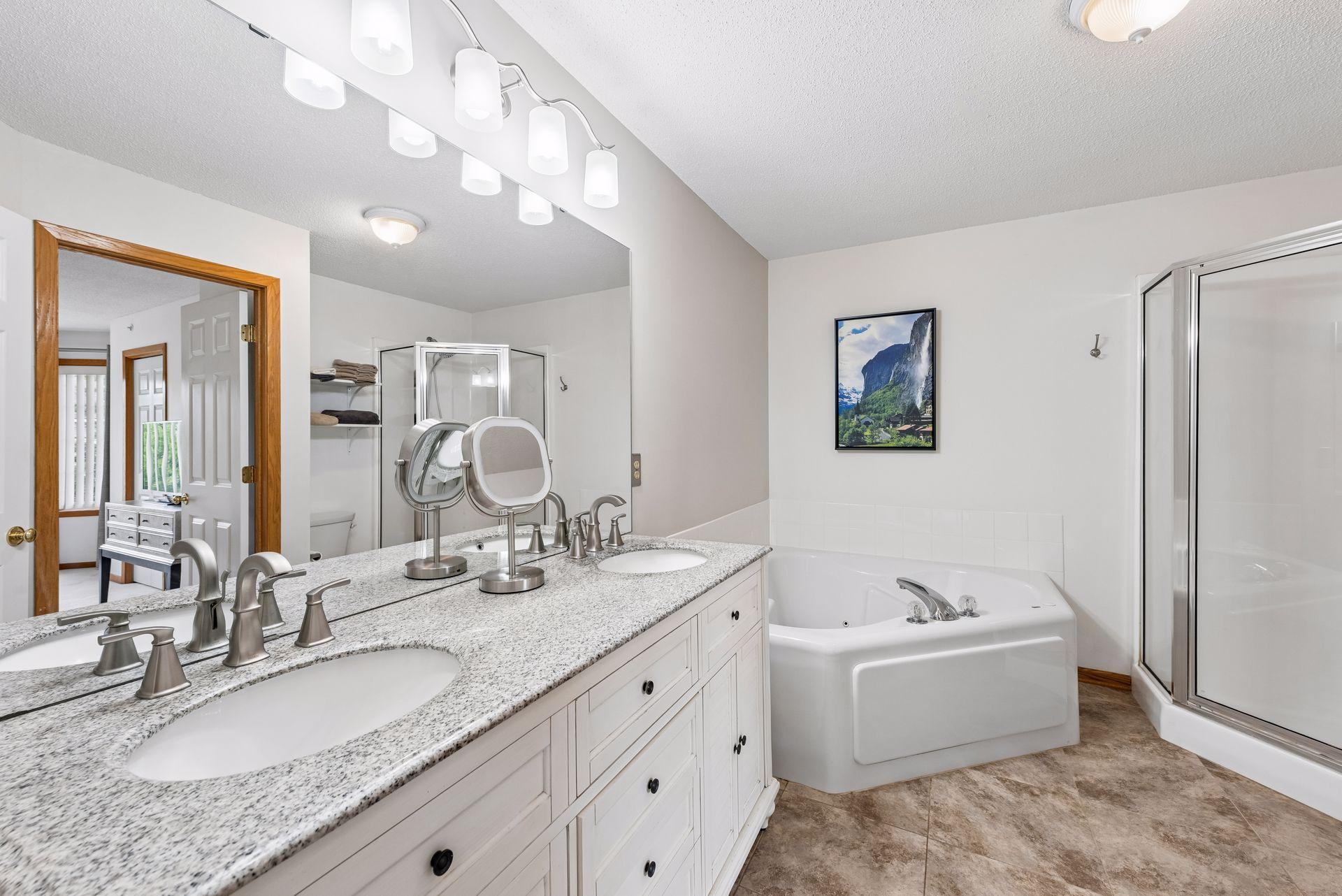 The attached full bath has a white cabinet-style vanity with double bowl undermount sinks.