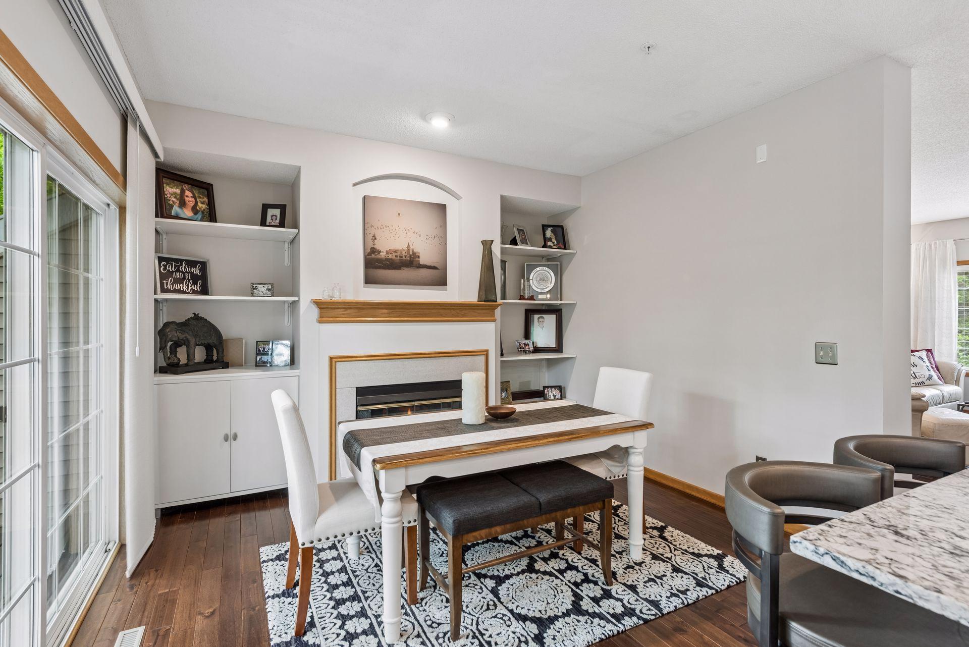 Dining room is open to the kitchen and features a gas fireplace with flanking shelving & cabinets.